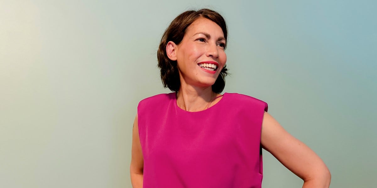 woman smiling, wearing a hot pink top