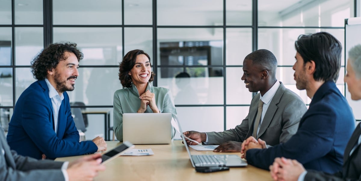 group of professionals sitting at a table in conference room